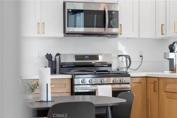 a kitchen with stainless steel appliances granite countertop a stove and a white cabinets