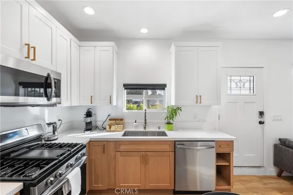 a kitchen with stainless steel appliances a sink stove and cabinets