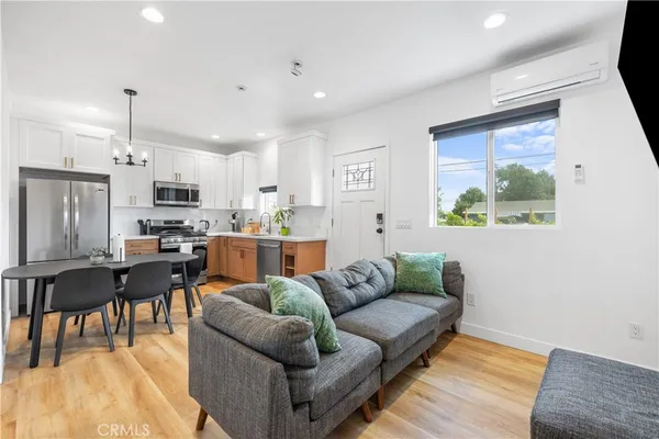a living room with stainless steel appliances furniture and a open kitchen view
