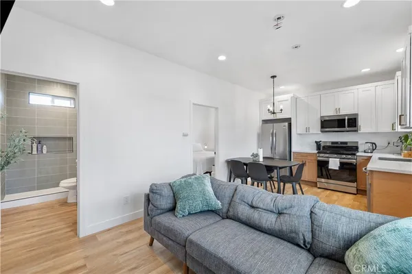 a living room with furniture kitchen and a wooden floor