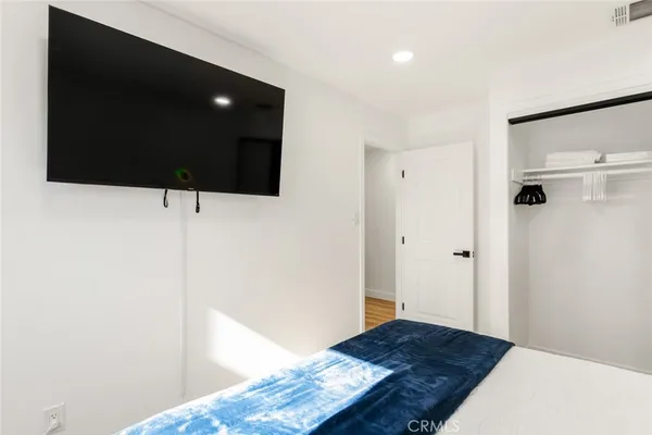 a living room with a bed and a flat screen tv