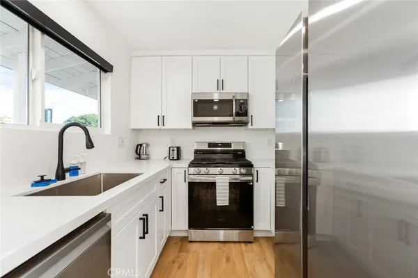 a kitchen with stainless steel appliances granite countertop a stove a sink and a refrigerator