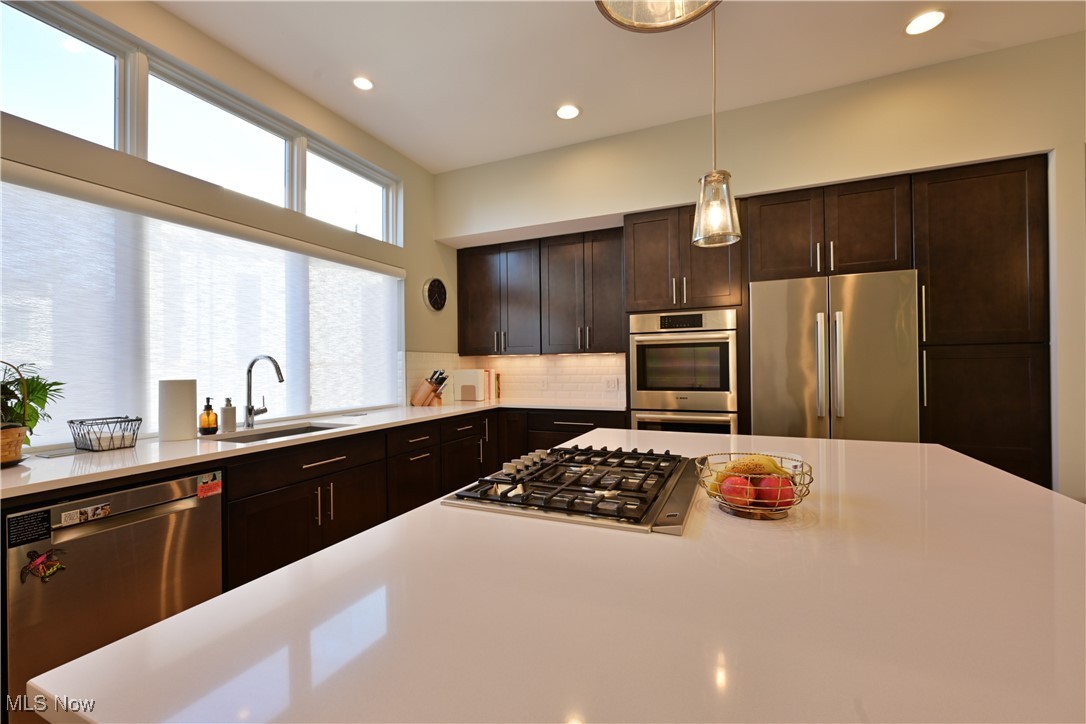 18875 Riversouth Fairview Park, Unit 30 Cleveland, OH 44126 - Photo 7 of 39 Kitchen featuring appliances with stainless steel finishes, dark brown cabinetry, decorative backsplash, recessed lighting, and pendant lighting