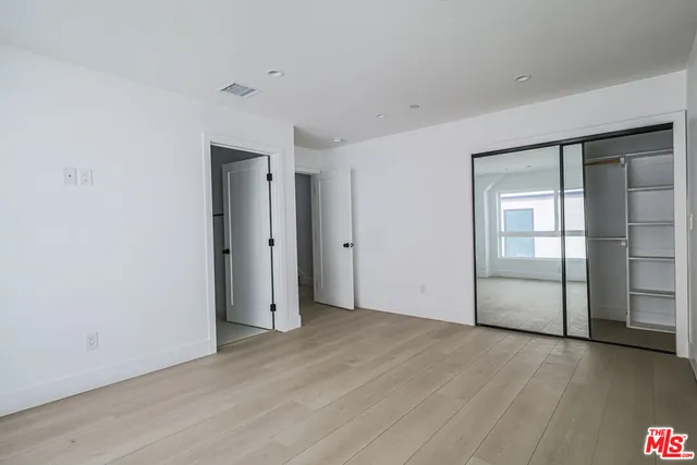 an empty room with wooden floor and closet