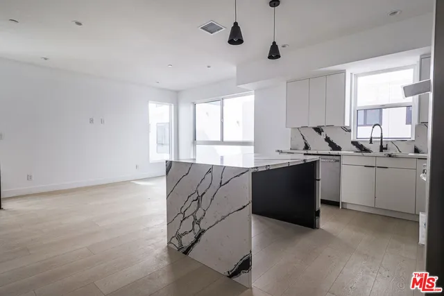 a kitchen with a sink window and cabinets