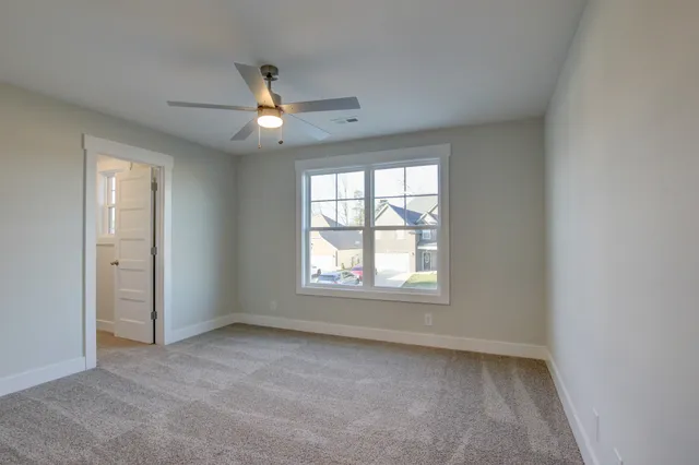 an empty room with a window and ceiling fan
