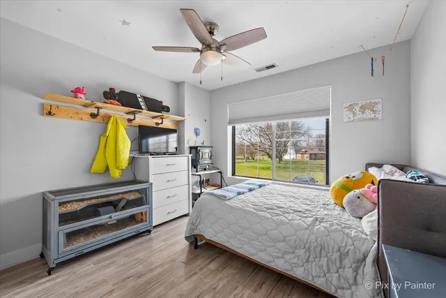 a bedroom with a bed a window and dresser