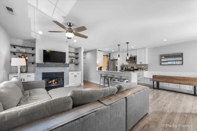a living room with furniture a fireplace and a flat screen tv