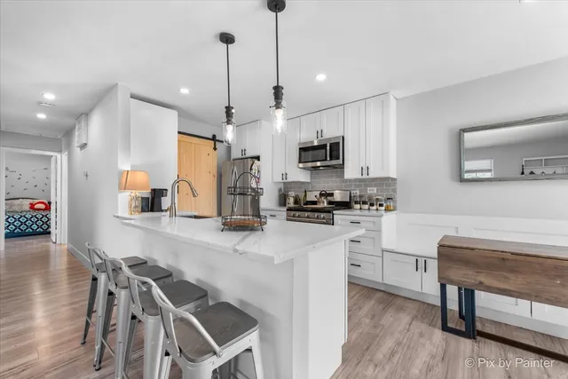 a kitchen with kitchen island a large counter top space appliances and cabinets