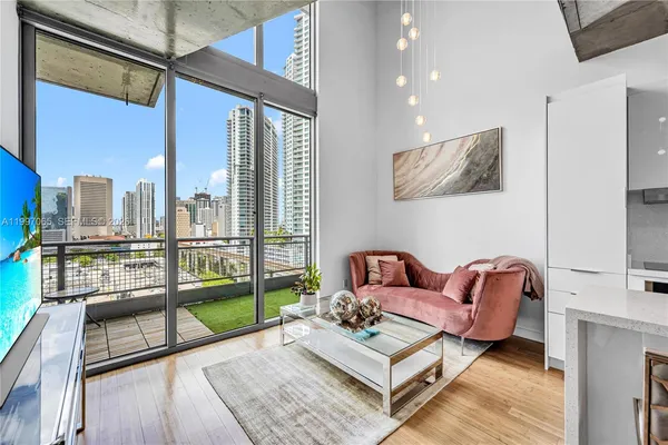 a living room with furniture floor to ceiling window and pool