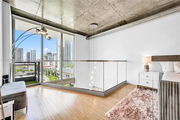 a bedroom with a bed a mirror and stairs