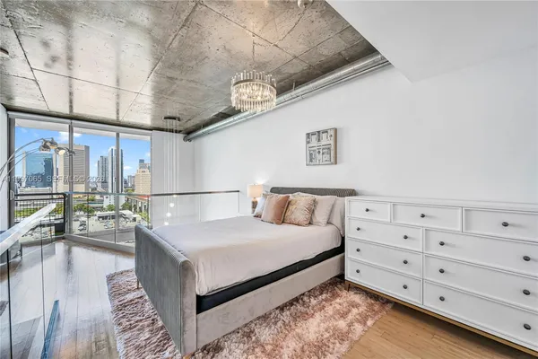 a bedroom with furniture and a large window