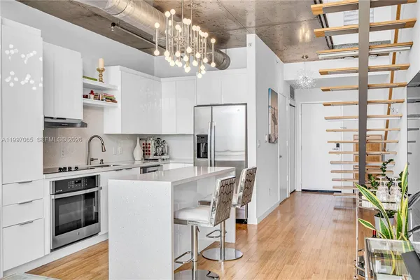 a kitchen with stainless steel appliances a sink a stove and cabinets