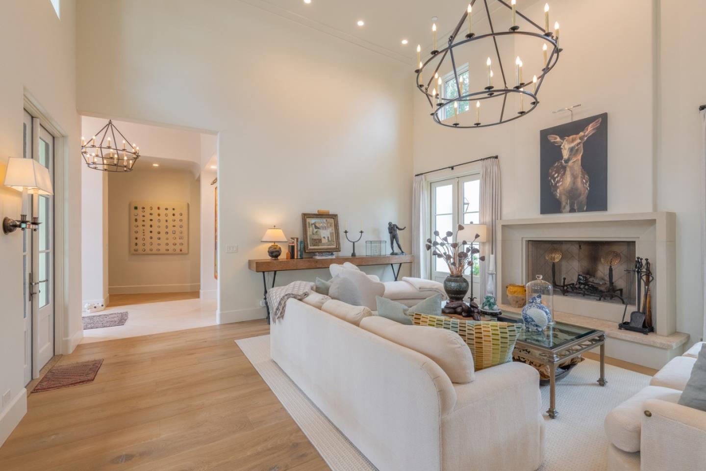 1041 Rodeo Road Pebble Beach, CA 93953 - Photo 4 of 18 a living room with furniture a chandelier and a fireplace