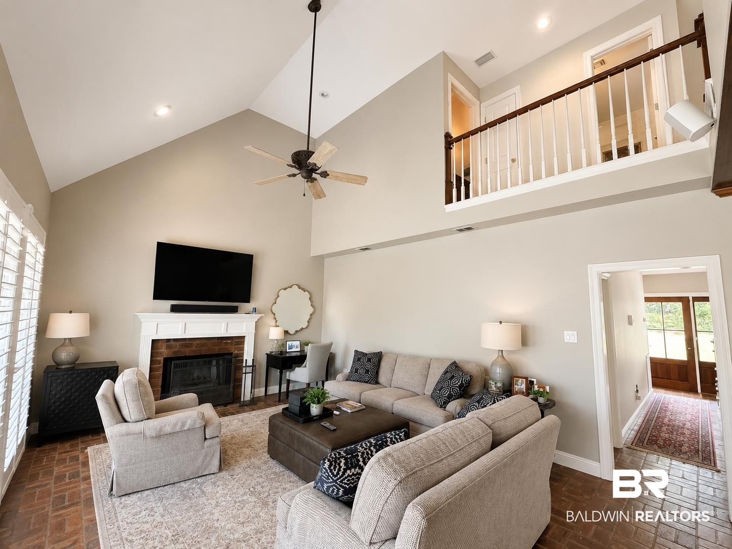 103 Raphael Semmes Drive East Spanish Fort, AL 36527 - Photo 3 of 9 Living room featuring a vaulted ceiling with a ceiling fan, brick fireplace with a white mantel, and brick-finish flooring