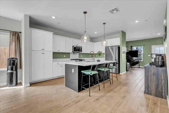 a kitchen with stainless steel appliances granite countertop a refrigerator a stove a sink and a refrigerator