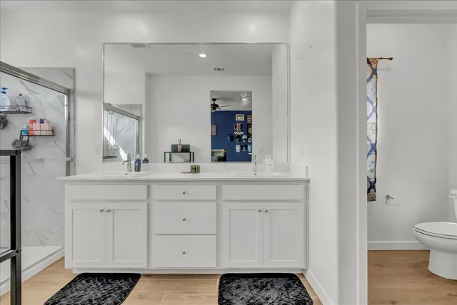 a bathroom with a double vanity sink mirror and shower