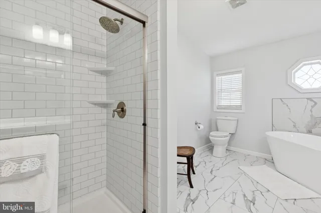 a bathroom with a toilet a sink and shower