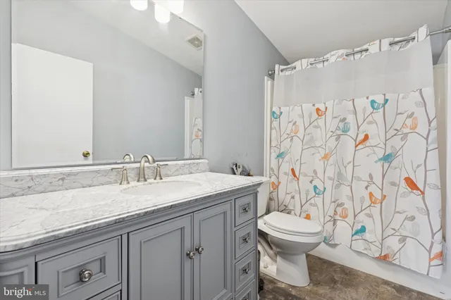 a bathroom with a granite countertop sink toilet and shower