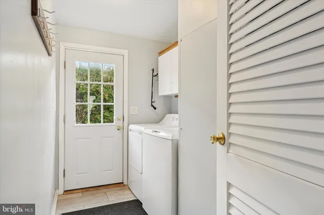 a view of washer and dryer with bathroom in the background