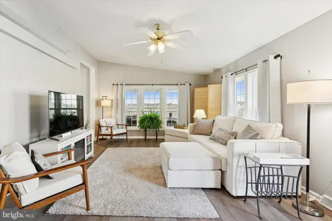 a living room with furniture a flat screen tv and a large window