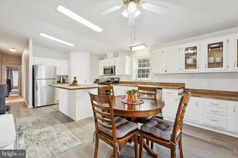a kitchen with a dining table chairs and white cabinets