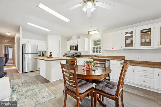 a kitchen with a dining table chairs and white cabinets