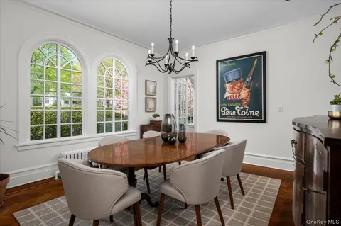 a dining room with furniture a chandelier and wooden floor