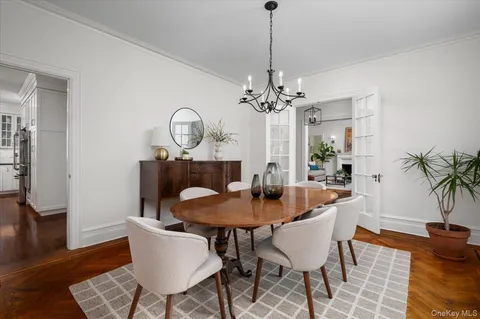 a dining room with furniture a chandelier and wooden floor