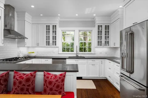 a kitchen with granite countertop a sink stainless steel appliances and cabinets