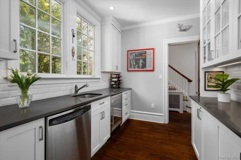 a kitchen with stainless steel appliances granite countertop a sink a stove and a wooden floor