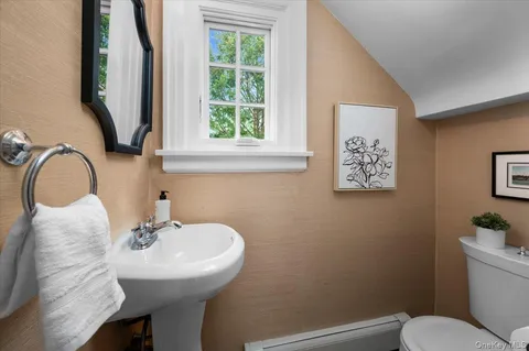 a bathroom with a sink mirror and toilet