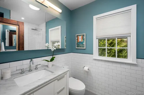 a bathroom with a granite countertop sink a toilet and a mirror