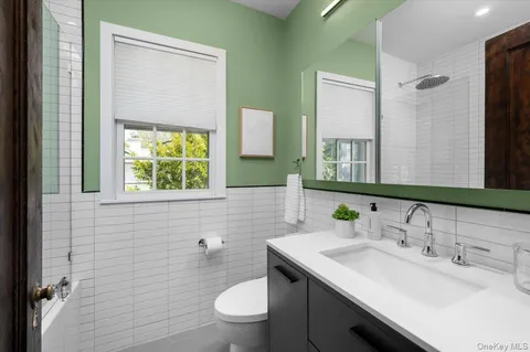 a bathroom with a toilet a sink a vanity and mirror