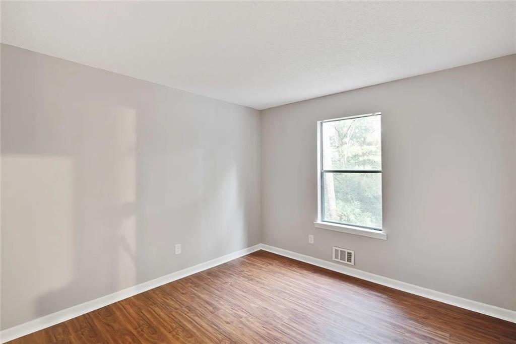 9825 Coleman Road Roswell, GA 30075 - Photo 11 of 17 an empty room with wooden floor and windows