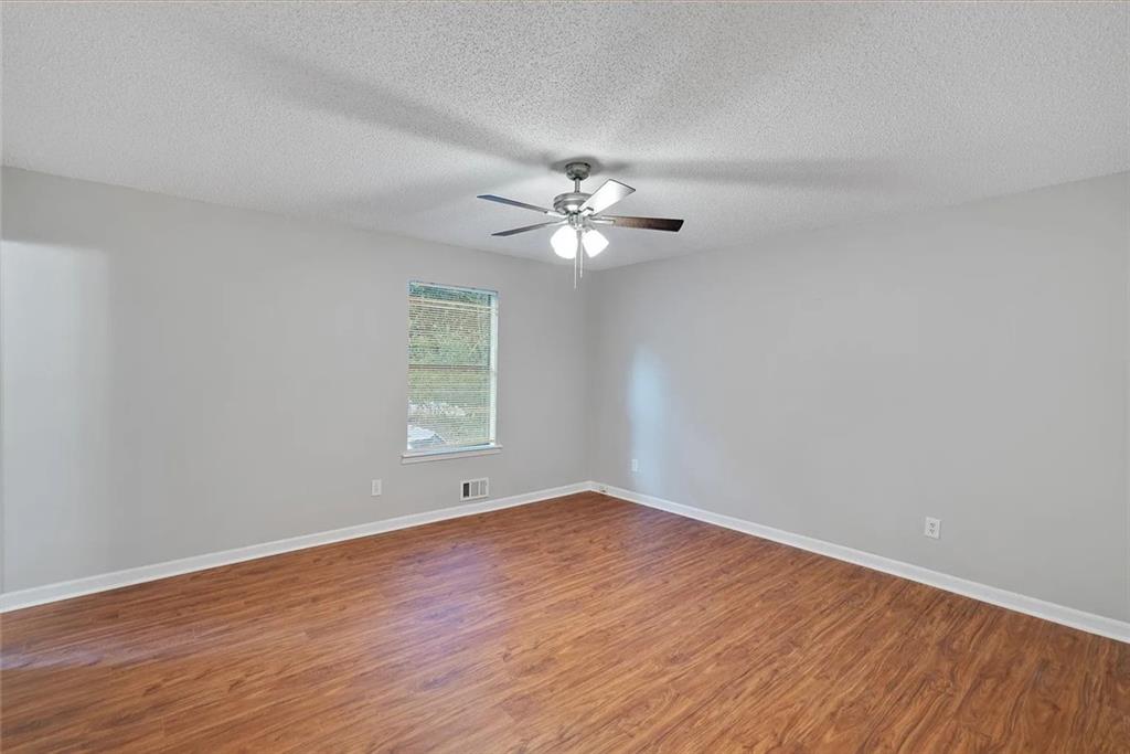 9825 Coleman Road Roswell, GA 30075 - Photo 13 of 17 a view of an empty room with wooden floor and a ceiling fan