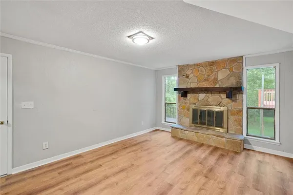 a view of a livingroom with wooden floor and a fireplace