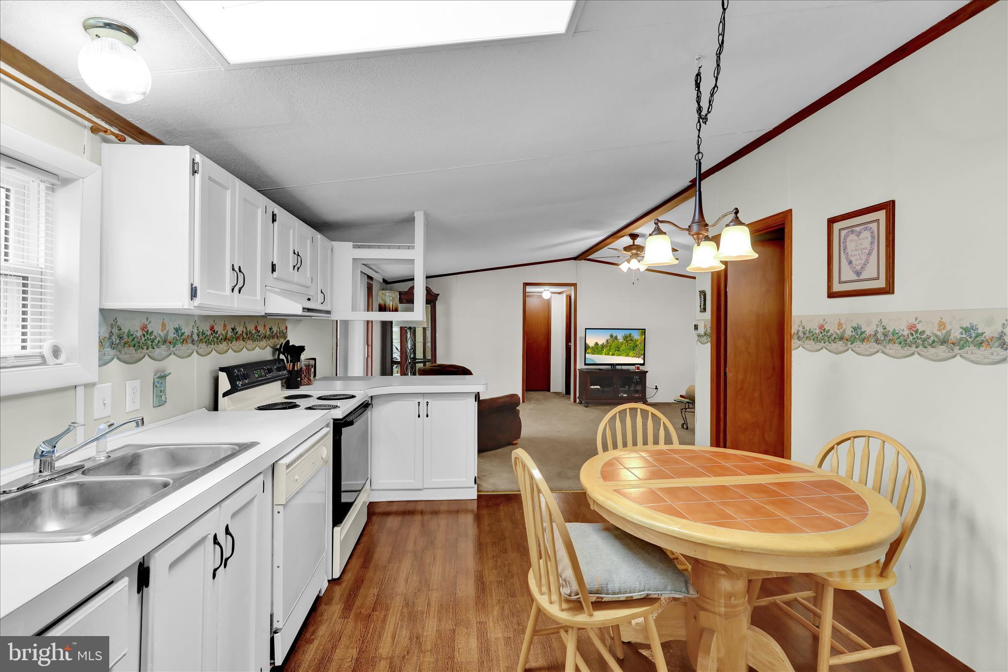8758 Turkey Ridge Road Breinigsville, PA 18031 - Photo 18 of 29 a kitchen with stainless steel appliances granite countertop a sink a stove a kitchen island with chairs and white cabinets