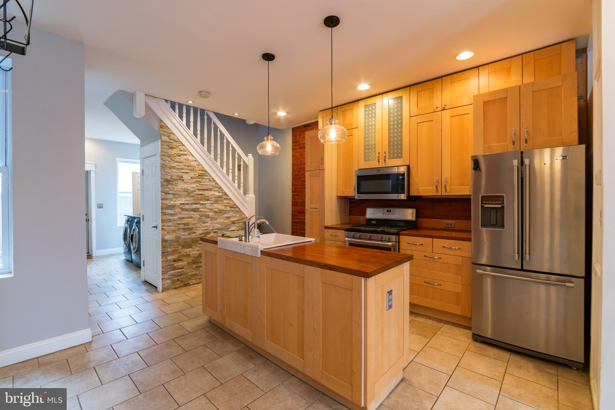 a kitchen with stainless steel appliances granite countertop a refrigerator a oven and white cabinets