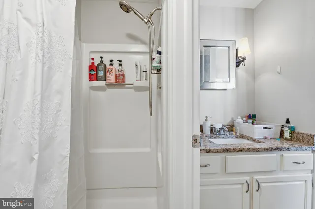 a bathroom with a granite countertop sink and a mirror