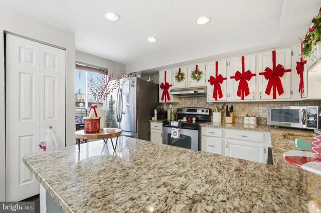 a kitchen with stainless steel appliances granite countertop a refrigerator and stove top oven