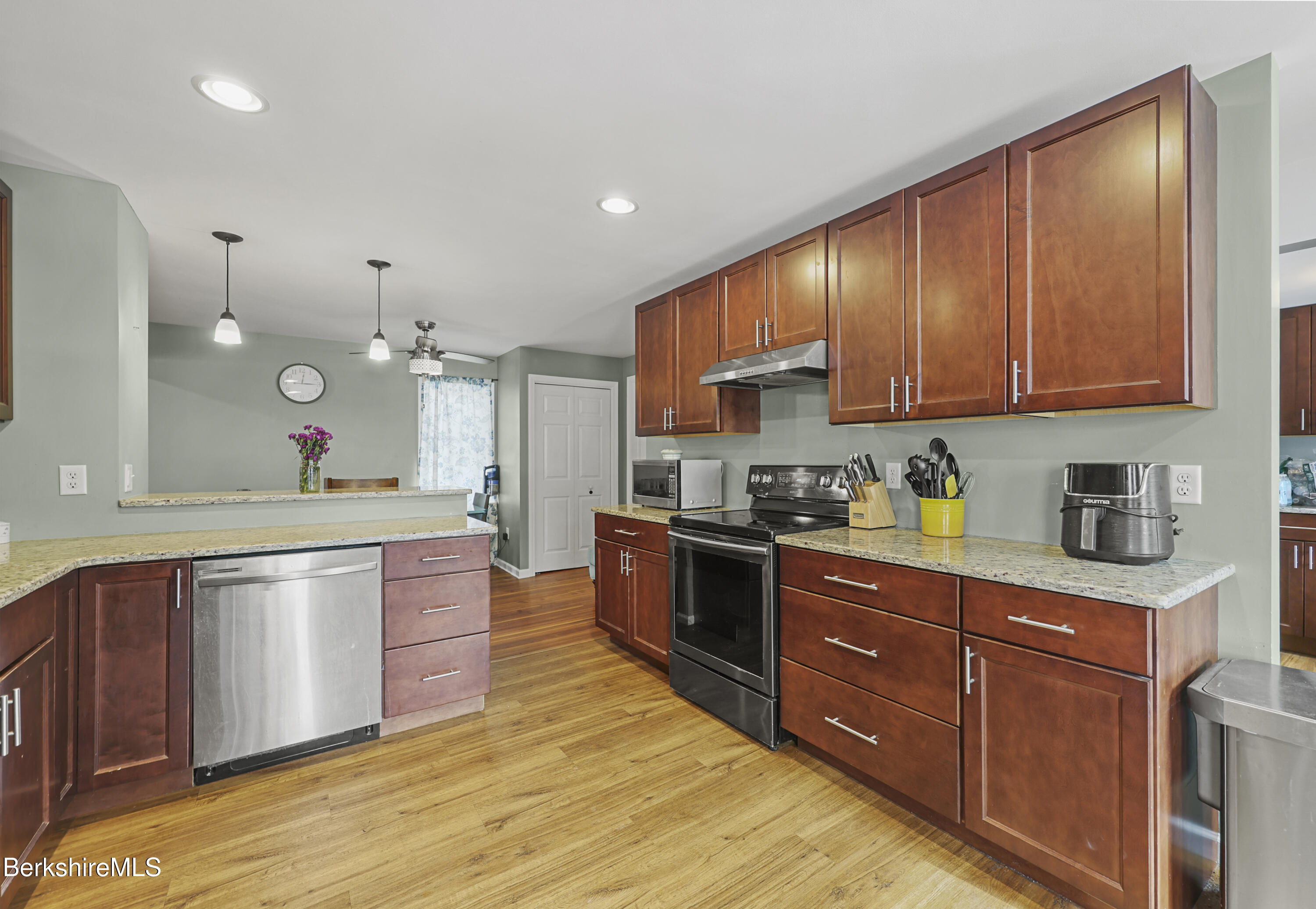 40 Stearns Avenue Pittsfield, MA 01201 - Photo 10 of 25 a large kitchen with stainless steel appliances granite countertop a stove a sink dishwasher and a refrigerator with wooden cabinets