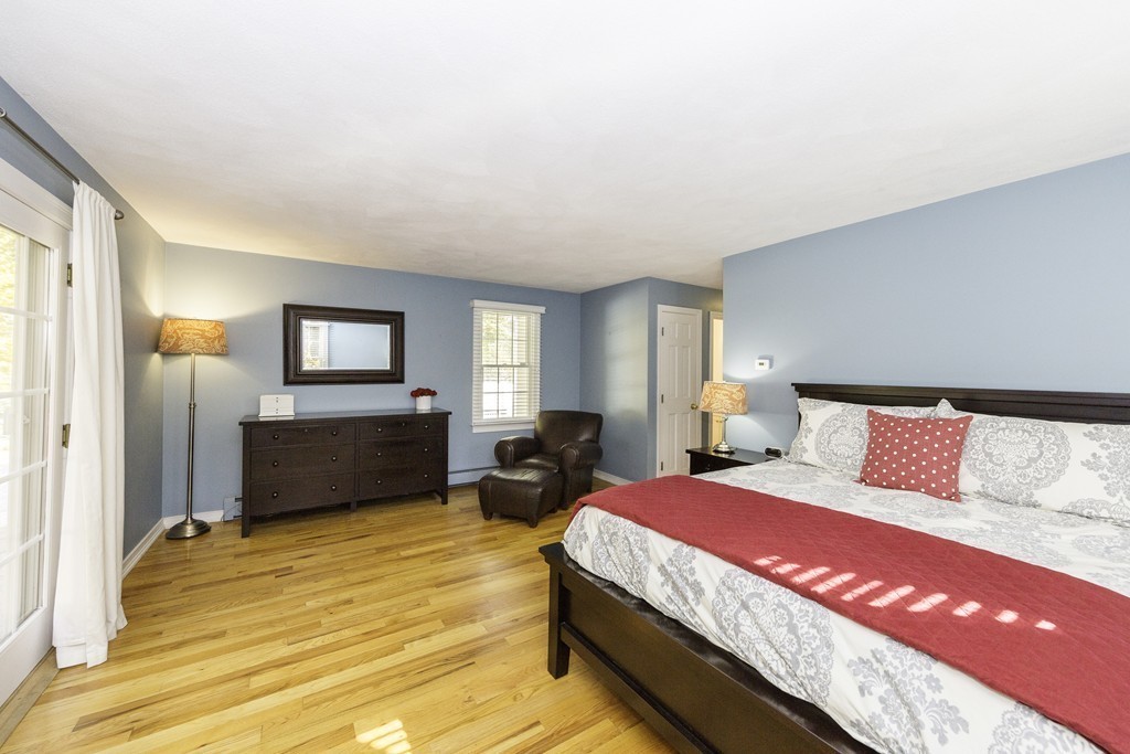 18 Paige Farm Road Amesbury, MA 01913 - Photo 15 of 28 a bedroom with a bed a mirror on dresser and a chandelier