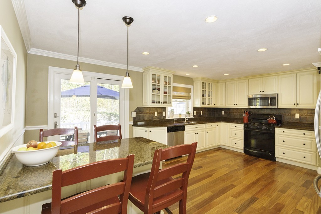18 Paige Farm Road Amesbury, MA 01913 - Photo 10 of 28 a kitchen with stainless steel appliances kitchen island granite countertop a stove a sink and white cabinets with wooden floors