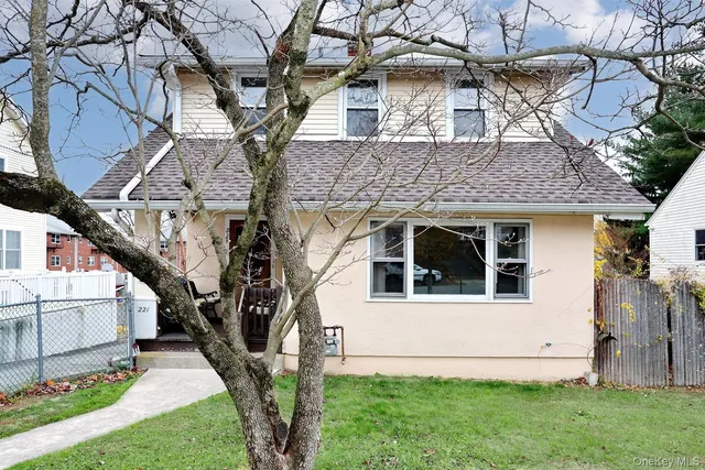 a white house that has tree in front of it