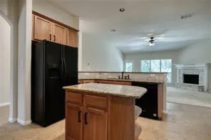 a kitchen with a sink a refrigerator and a fireplace