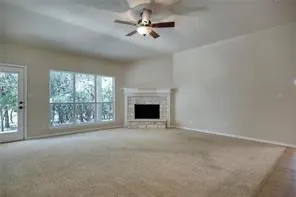 a view of an empty room with a fireplace and a window