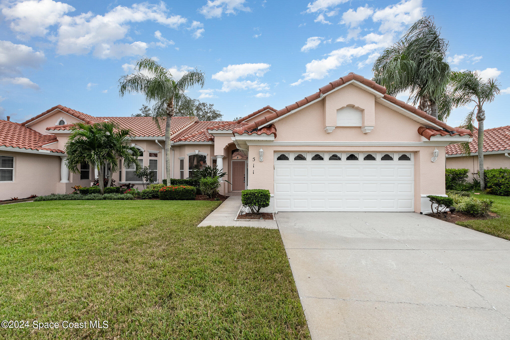 511 Shell Cove Drive Melbourne, FL 32940 - Photo 2 of 31 a front view of a house with a yard and garage
