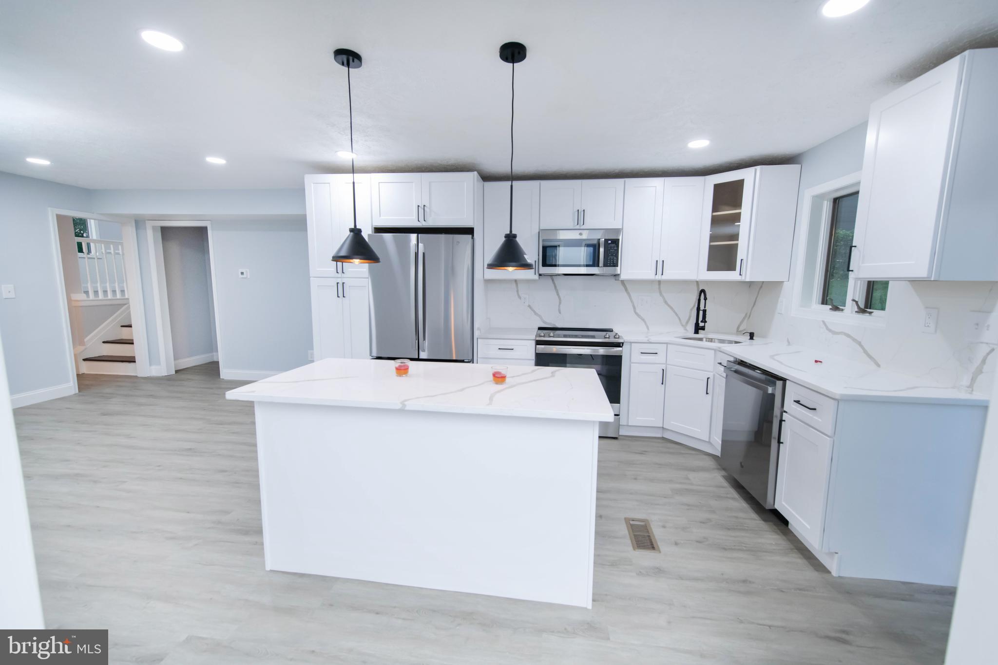 a kitchen with kitchen island a white cabinets and refrigerator