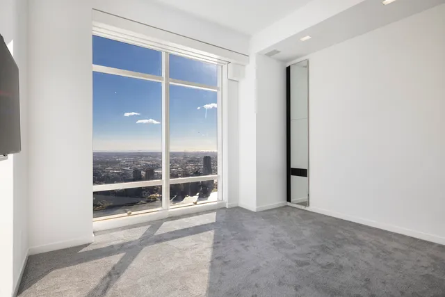 a bedroom with a large bed and a potted plant